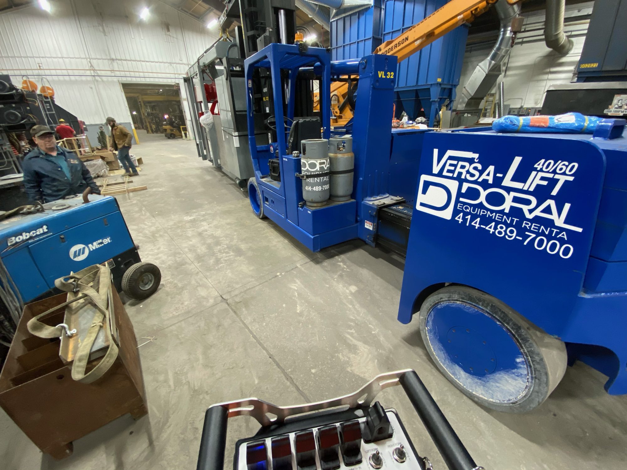 Cork crew moving industrial equipment with a Versa-Lift machine inside a shop